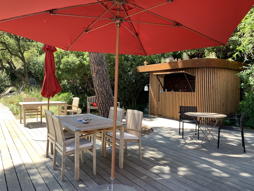 Terrasse avec parasols rouges et cuisine d'été au Lavandou
